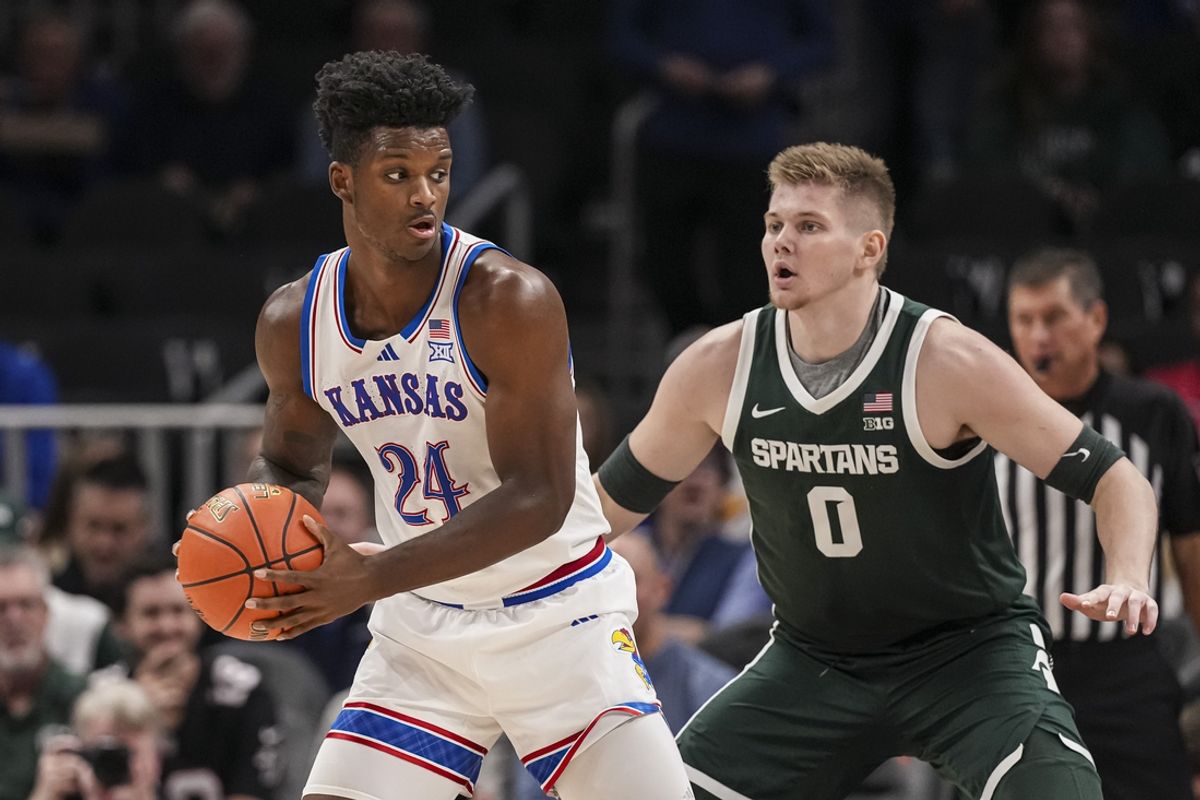 Nov 12, 2024; Atlanta, Georgia, USA; Kansas Jayhawks forward KJ Adams Jr. (24) controls the ball defended by Michigan State Spartans forward Jaxon Kohler (0) during the first half at State Farm Arena. Mandatory Credit: Dale Zanine-Imagn Images