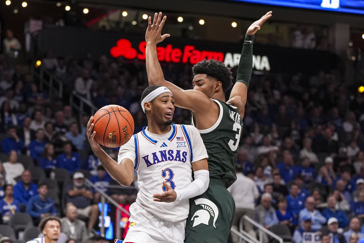 Nov 12, 2024; Atlanta, Georgia, USA; Kansas Jayhawks guard Dajuan Harris Jr. (3) passes around Michigan State Spartans guard Jaden Akins (3) during the second half at State Farm Arena. Mandatory Credit: Dale Zanine-Imagn Images