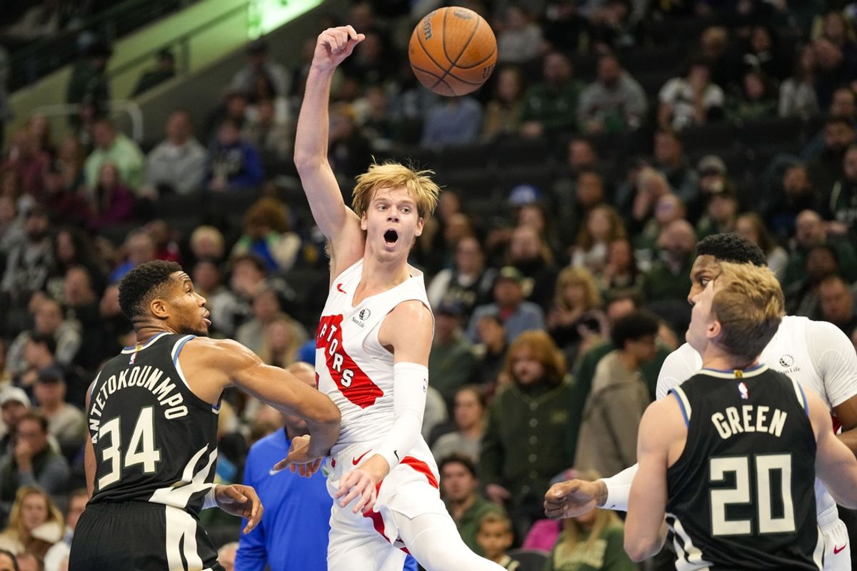 Nov 12, 2024; Milwaukee, Wisconsin, USA;  Toronto Raptors guard Gradey Dick (1) passes the ball away from Milwaukee Bucks forward Giannis Antetokounmpo (34) during the second quarter at Fiserv Forum. Mandatory Credit: Jeff Hanisch-Imagn Images