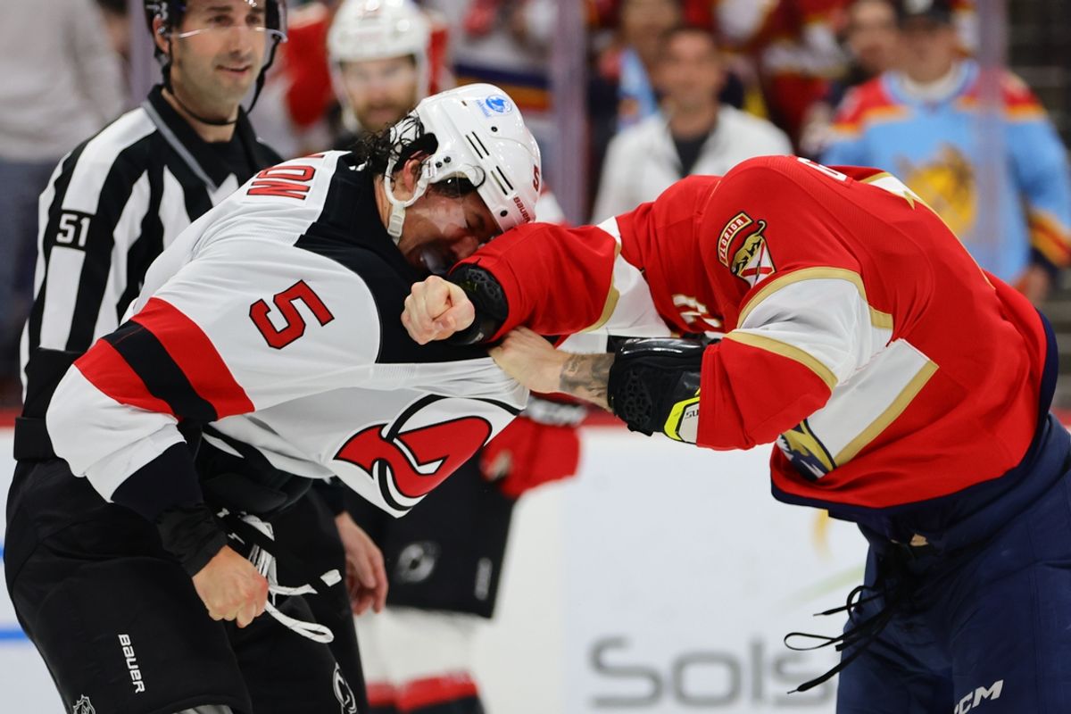 Nov 12, 2024; Sunrise, Florida, USA; New Jersey Devils defenseman Brenden Dillon (5) and Florida Panthers left wing Jonah Gadjovich (12) fight during the second period at Amerant Bank Arena. Mandatory Credit: Sam Navarro-Imagn Images