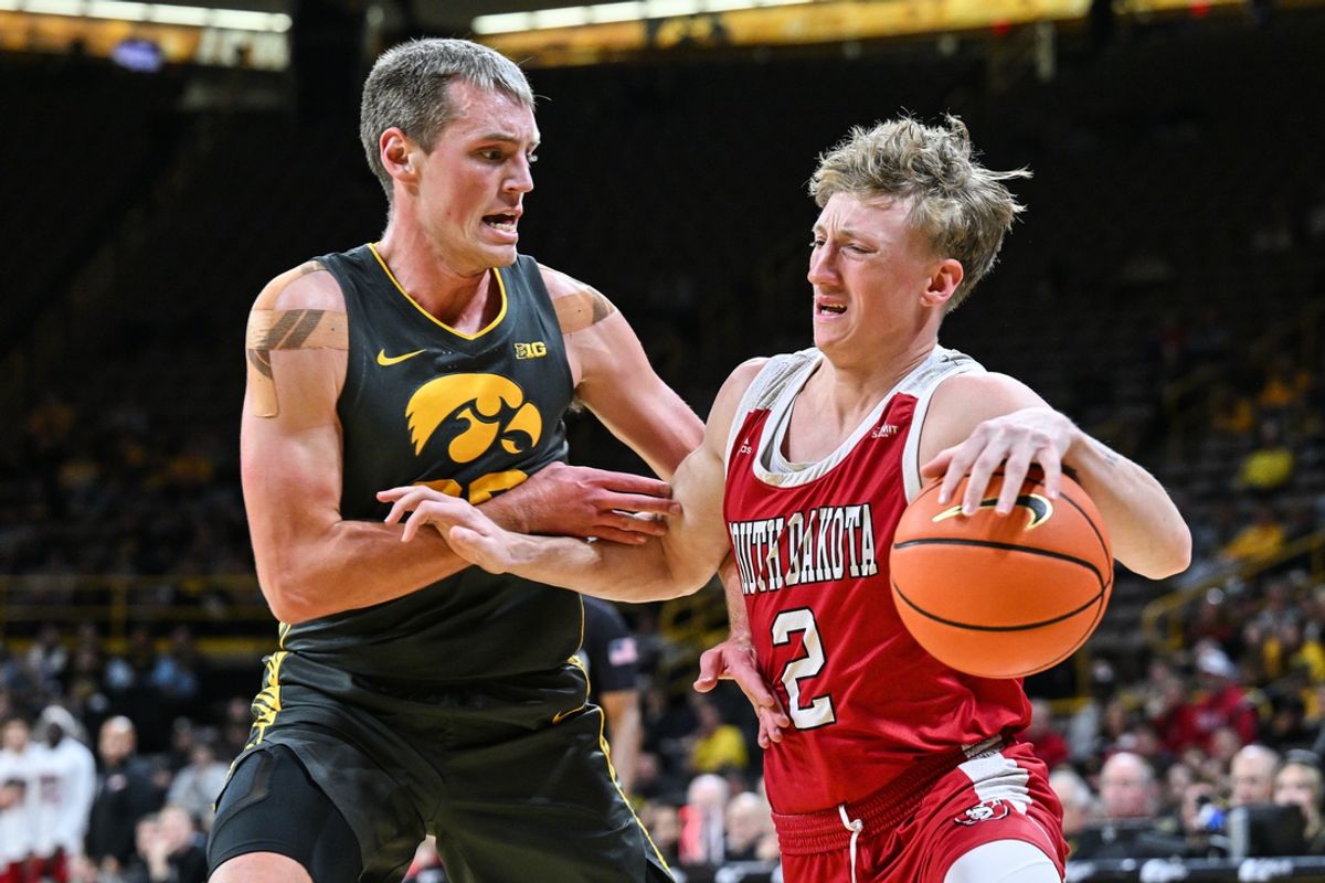 Nov 12, 2024; Iowa City, Iowa, USA; South Dakota Coyotes guard Shey Eberwein (2) drives against Iowa Hawkeyes forward Payton Sandfort (20) during the first half at Carver-Hawkeye Arena. Mandatory Credit: Jeffrey Becker-Imagn Images
