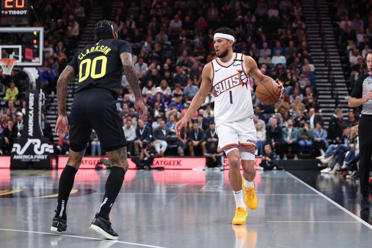 Nov 12, 2024; Salt Lake City, Utah, USA; Phoenix Suns guard Devin Booker (1) brings the ball up the court against Utah Jazz guard Jordan Clarkson (00) during the second quarter at Delta Center. Mandatory Credit: Rob Gray-Imagn Images