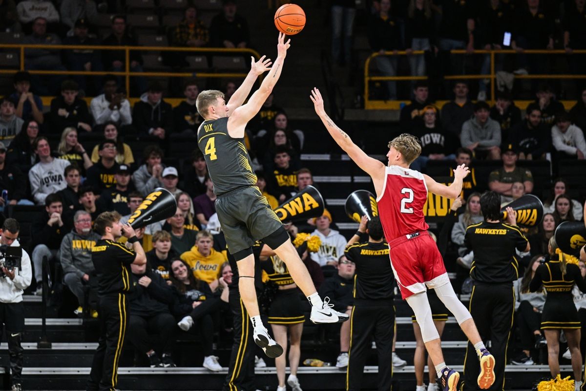 Nov 12, 2024; Iowa City, Iowa, USA; Iowa Hawkeyes guard Josh Dix (4) shoots against South Dakota Coyotes guard Shey Eberwein (2) during the first half at Carver-Hawkeye Arena. Mandatory Credit: Jeffrey Becker-Imagn Images