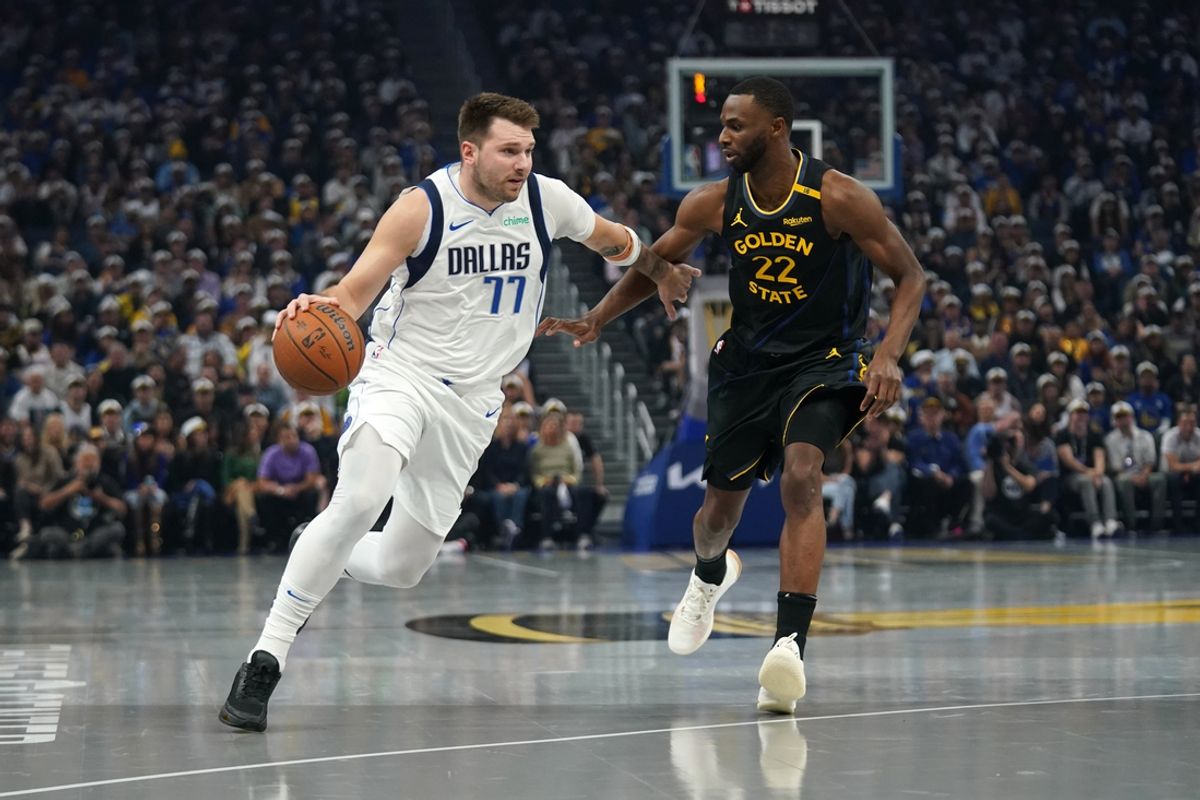 Nov 12, 2024; San Francisco, California, USA; Dallas Mavericks guard Luka Doncic (77) dribbles past Golden State Warriors forward Andrew Wiggins (22) in the first quarter at the Chase Center. Mandatory Credit: Cary Edmondson-Imagn Images