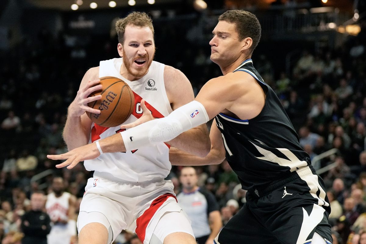 Nov 12, 2024; Milwaukee, Wisconsin, USA;  Toronto Raptors center Jakob Poeltl (19) drives for the basket against Milwaukee Bucks center Brook Lopez (11) during the first quarter at Fiserv Forum. Mandatory Credit: Jeff Hanisch-Imagn Images
