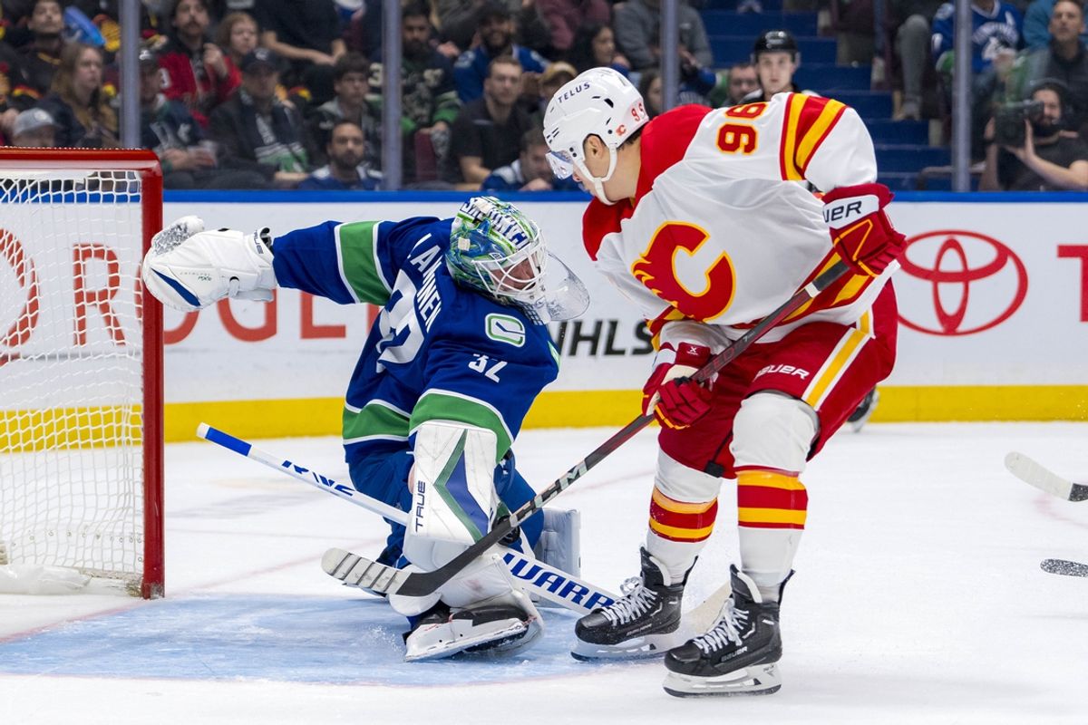 Nov 12, 2024; Vancouver, British Columbia, CAN; Vancouver Canucks goalie Kevin Lankinen (32) makes a save against Calgary Flames forward Andrei Kuzmenko (96) during the first period at Rogers Arena. Mandatory Credit: Bob Frid-Imagn Images
