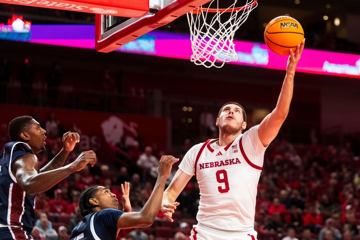 Nov 13, 2024; Lincoln, Nebraska, USA; Nebraska Cornhuskers forward Berke Buyuktuncel (9) shoots the ball against Fairleigh Dickinson Knights guard Ahmed Barba-Bey (8) and guard Josiah Francis (15) during the first half at Pinnacle Bank Arena. Mandatory Credit: Dylan Widger-Imagn Images