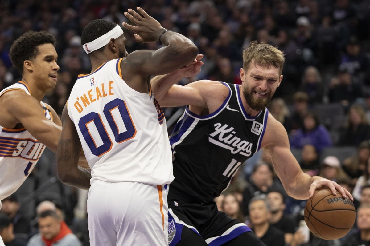 November 13, 2024; Sacramento, California, USA; Sacramento Kings forward Domantas Sabonis (11) is defended by Phoenix Suns forward Royce O'Neale (00) during the second quarter at Golden 1 Center. Mandatory Credit: Kyle Terada-Imagn Images