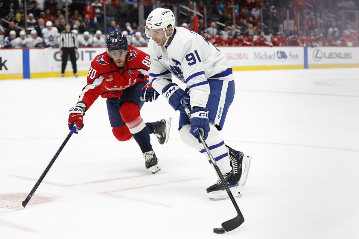 Nov 13, 2024; Washington, District of Columbia, USA; Toronto Maple Leafs center John Tavares (91) skates with the puck as Washington Capitals left wing Pierre-Luc Dubois (80) chases in overtime at Capital One Arena. Mandatory Credit: Geoff Burke-Imagn Images