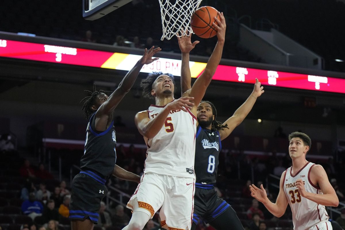 Nov 13, 2024; Los Angeles, California, USA; Southern California Trojans forward Terrance Williams II (5) shoots the ball against Texas-Arlington Mavericks guard Darius Burford (12) and forward Troy Hupstead (8) during the first half at Galen Center. Mandatory Credit: Kirby Lee-Imagn Images