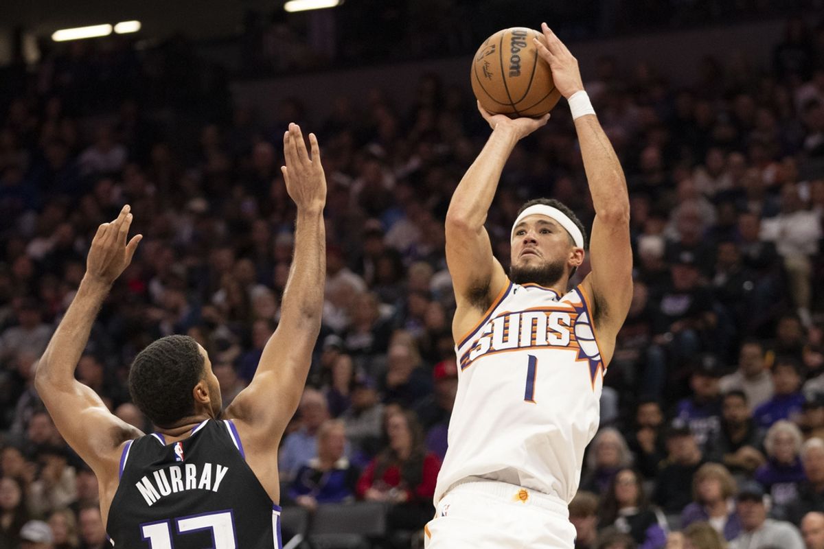November 13, 2024; Sacramento, California, USA; Phoenix Suns guard Devin Booker (1) shoots the basketball against Sacramento Kings forward Keegan Murray (13) during the third quarter at Golden 1 Center. Mandatory Credit: Kyle Terada-Imagn Images