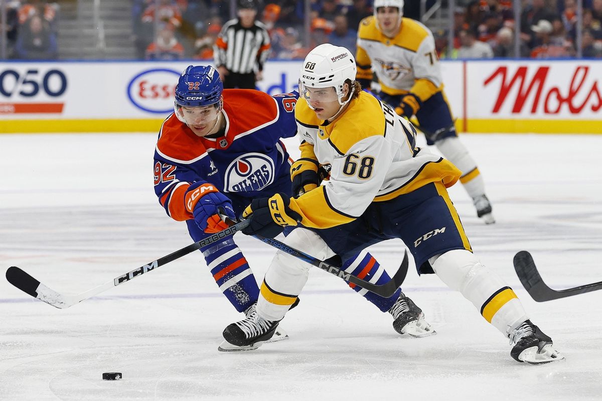 Nov 14, 2024; Edmonton, Alberta, CAN; Nashville Predators forward Zach L'Heureux (68) tries to move the puck past Edmonton Oilers forward Vasily Podkolzin (92) during the second period at Rogers Place. Mandatory Credit: Perry Nelson-Imagn Images