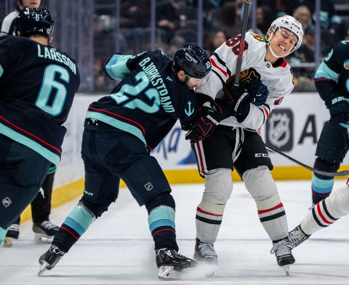 Nov 14, 2024; Seattle, Washington, USA;  Seattle Kraken forward Oliver Bjorkstrand (22) tangles with Chicago Blackhawks forward Connor Bedard (98) during the second period at Climate Pledge Arena. Mandatory Credit: Stephen Brashear-Imagn Images