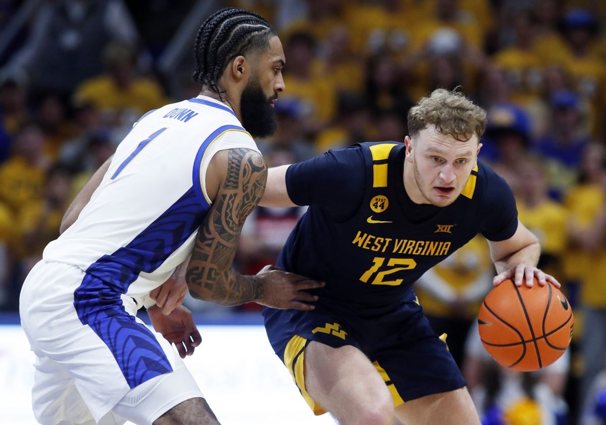 Nov 15, 2024; Pittsburgh, Pennsylvania, USA;  West Virginia Mountaineers guard Tucker DeVries (12) brings the ball up court against pressure from Pittsburgh Panthers guard Damian Dunn (1) during the first half at the Petersen Events Center. Mandatory Credit: Charles LeClaire-Imagn Images