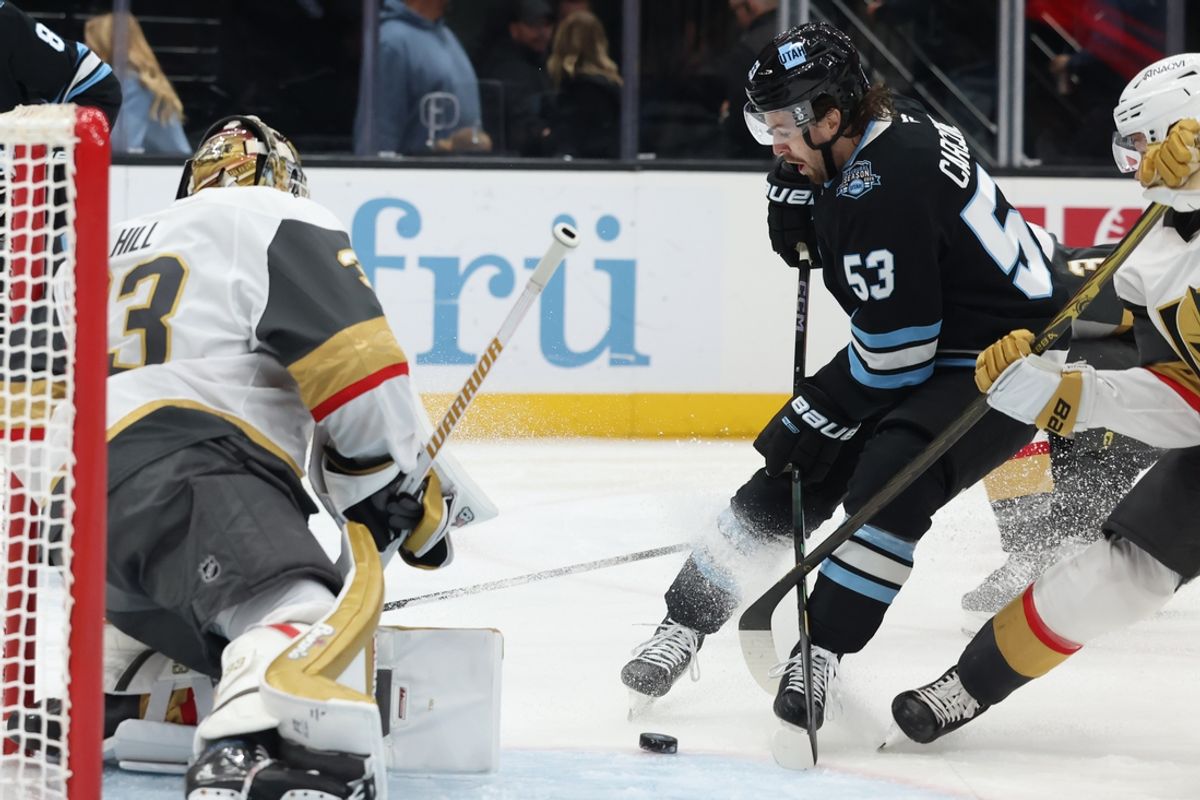 Nov 15, 2024; Salt Lake City, Utah, USA; Utah Hockey Club left wing Michael Carcone (53) plays the puck against Vegas Golden Knights goaltender Adin Hill (33) during the second period at Delta Center. Mandatory Credit: Rob Gray-Imagn Images