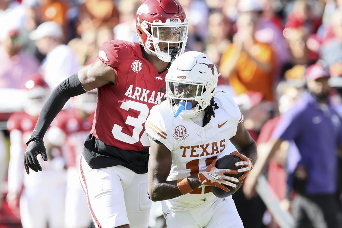 Nov 16, 2024; Fayetteville, Arkansas, USA; Texas Longhorns wide receiver Silas Bolden (11) runs the ball in the first quarter as Arkansas Razorbacks linebacker Larry Worth III (30) defends at Donald W. Reynolds Razorback Stadium. Mandatory Credit: Nelson Chenault-Imagn Images