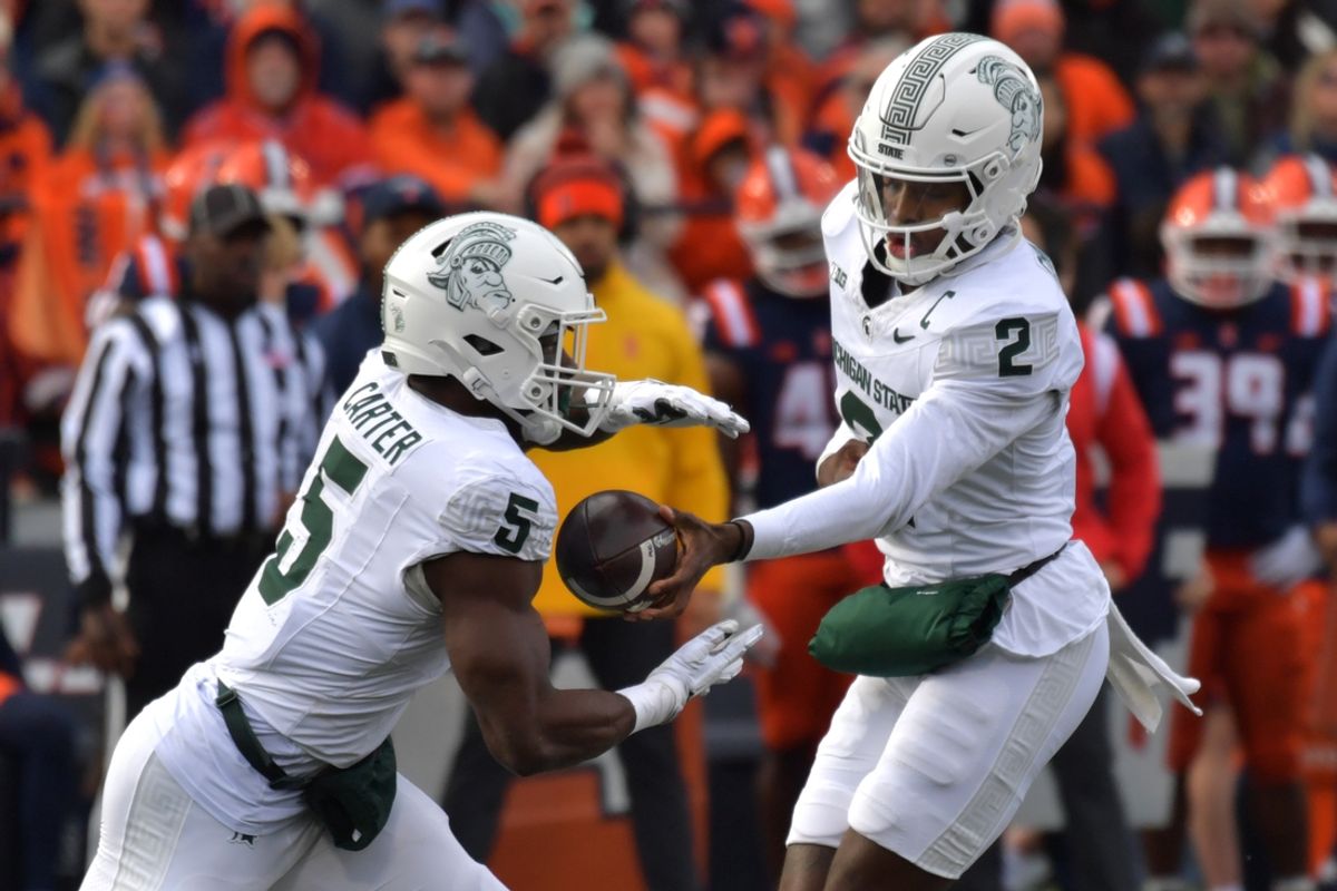 Nov 16, 2024; Champaign, Illinois, USA; Michigan State Spartans quarterback Aidan Chiles (2) hands the ball to running back Nate Carter (5) during the first half against the Illinois Fighting Illini at Memorial Stadium. Mandatory Credit: Ron Johnson-Imagn Images