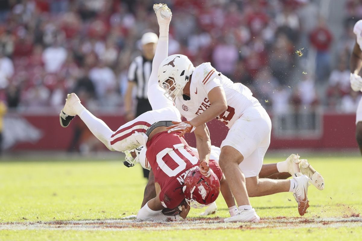 Nov 16, 2024; Fayetteville, Arkansas, USA; Arkansas Razorbacks quarterback Taylen Green (10) is tackled by Texas Longhorns defensive back Jaylon Guilbeau (3) as linebacker Liona Leaf (18) defends during the fourth quarter at Donald W. Reynolds Razorback Stadium. Texas won 20-10. Mandatory Credit: Nelson Chenault-Imagn Images
