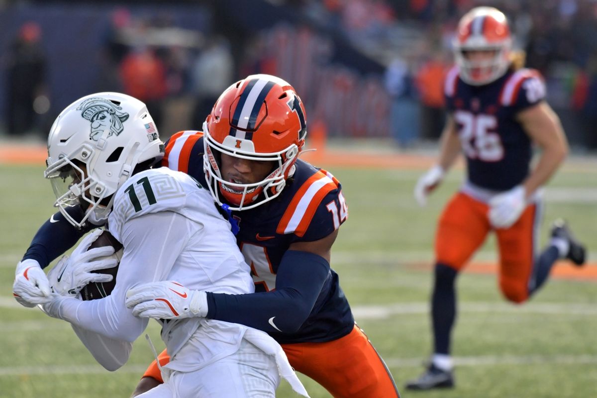 Nov 16, 2024; Champaign, Illinois, USA; Illinois Fighting Illini defensive back Xavier Scott (14) tackles Michigan State receiver Aziah Johnson (11) during the first half at Memorial Stadium. Mandatory Credit: Ron Johnson-Imagn Images