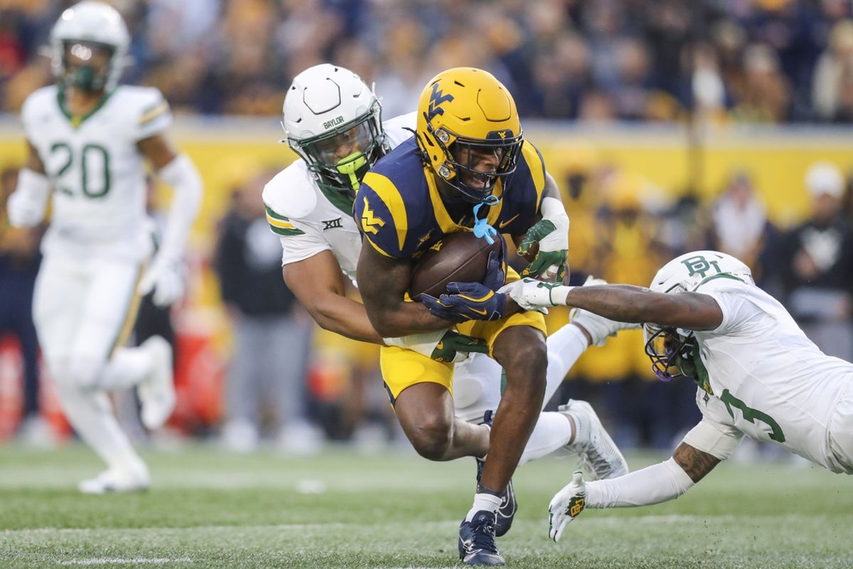 Nov 16, 2024; Morgantown, West Virginia, USA; West Virginia Mountaineers wide receiver Traylon Ray (7) catches a pass and is tackled by Baylor Bears linebacker Keaton Thomas (11) during the first quarter at Mountaineer Field at Milan Puskar Stadium. Mandatory Credit: Ben Queen-Imagn Images