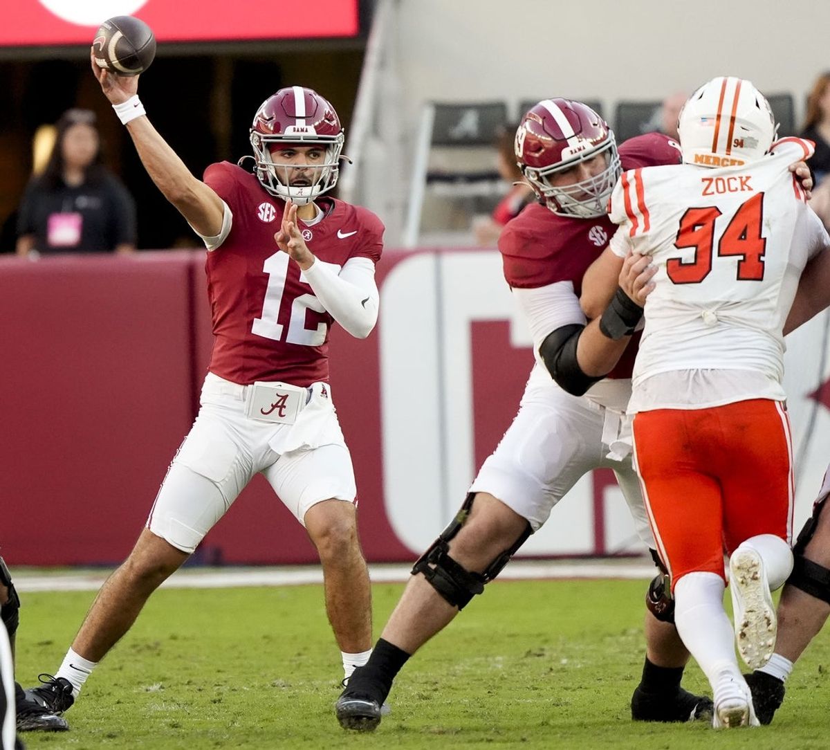 Nov 16, 2024; Tuscaloosa, AL, USA; Alabama Crimson Tide quarterback Dylan Lonergan (12) throws a pass offensive lineman Joseph Ionata (69) blocking on Mercer Bears defensive lineman Andrew Zock (94) at Bryant-Denny Stadium. Mandatory Credit: Gary Cosby Jr.-Imagn Images