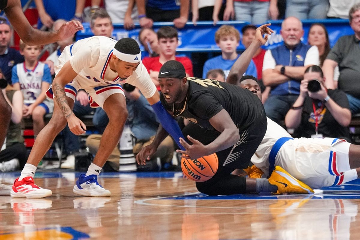 Nov 16, 2024; Lawrence, Kansas, USA; Kansas Jayhawks guard Dajuan Harris Jr. (3) and Oakland Golden Grizzlies guard DQ Cole (10) and forward Flory Bidunga (40) fight for a loose ball during the second half at Allen Fieldhouse. Mandatory Credit: Denny Medley-Imagn Images
