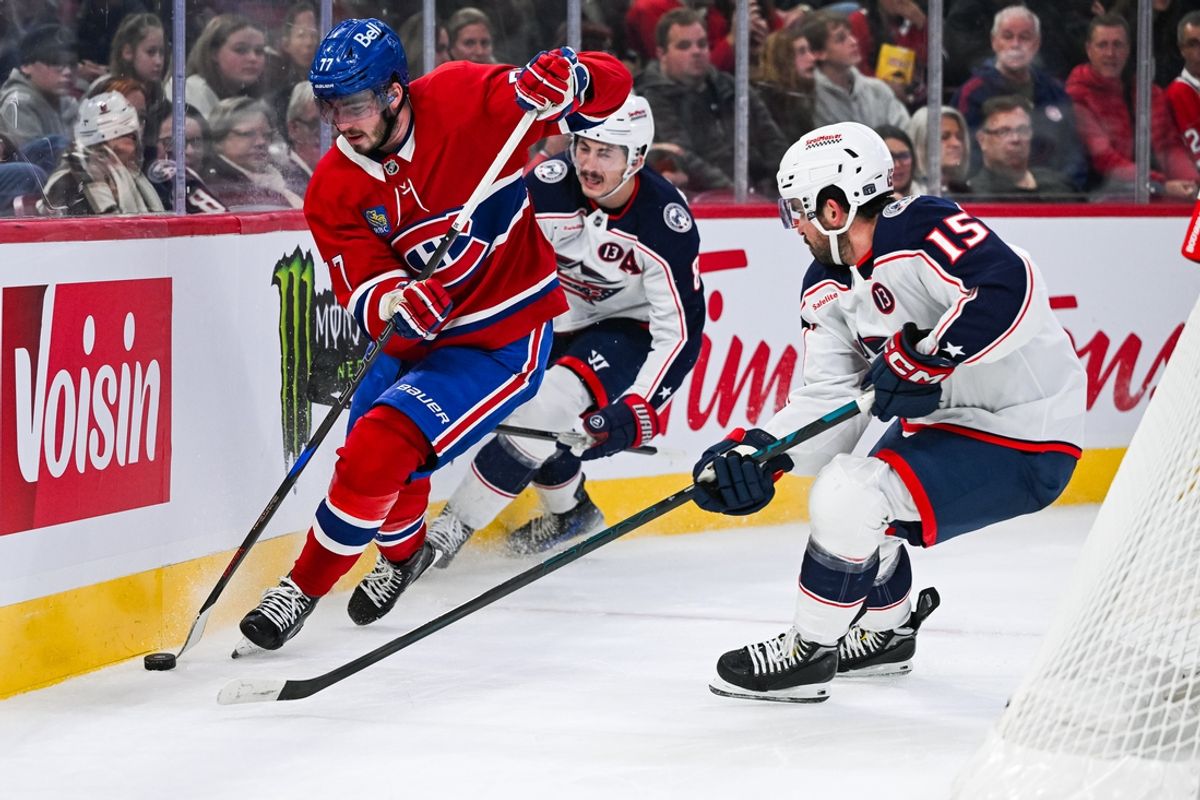 Nov 16, 2024; Montreal, Quebec, CAN; Montreal Canadiens center Kirby Dach (77) plays the puck against Columbus Blue Jackets defenseman Dante Fabbro (15) during the second period at Bell Centre. Mandatory Credit: David Kirouac-Imagn Images