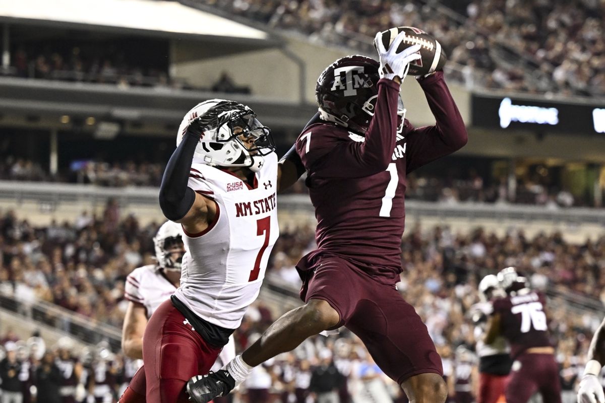 Nov 16, 2024; College Station, Texas, USA; Texas A&M Aggies wide receiver Moose Muhammad III (7) receives a pass for a touchdown as New Mexico State Aggies cornerback Keonte Glinton (7) defends during the second quarter at Kyle Field. Mandatory Credit: Maria Lysaker-Imagn Images