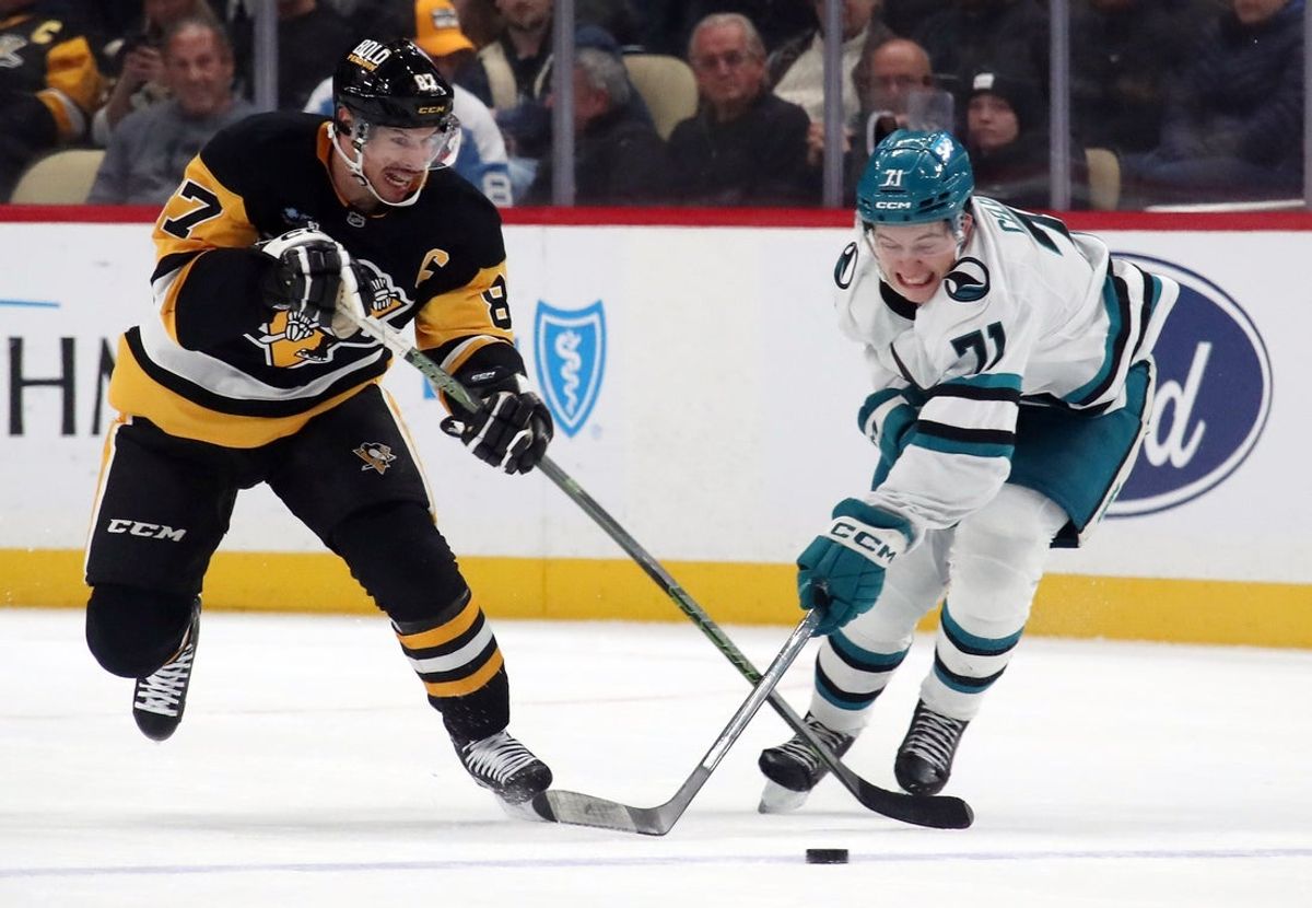 Nov 16, 2024; Pittsburgh, Pennsylvania, USA;  Pittsburgh Penguins center Sidney Crosby (87) and San Jose Sharks center Macklin Celebrini (71) battle to control the puck during the third period at PPG Paints Arena. Mandatory Credit: Charles LeClaire-Imagn Images