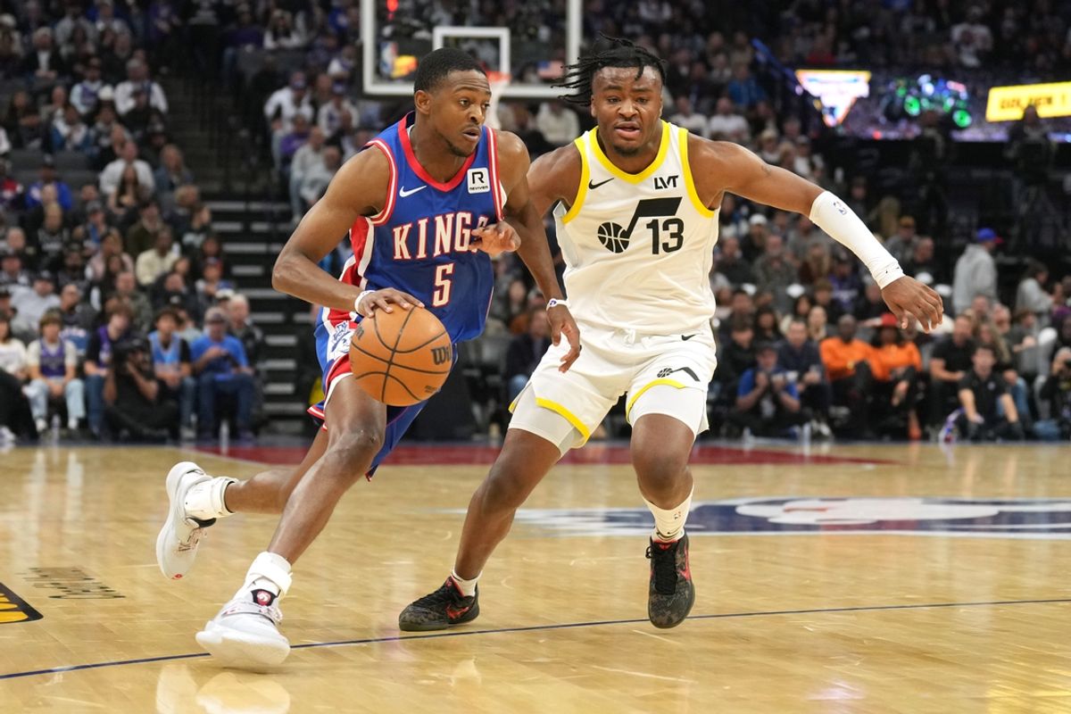 Nov 16, 2024; Sacramento, California, USA; Sacramento Kings guard De'Aaron Fox (5) dribbles against Utah Jazz guard Isaiah Collier (13) during the second quarter at Golden 1 Center. Mandatory Credit: Darren Yamashita-Imagn Images