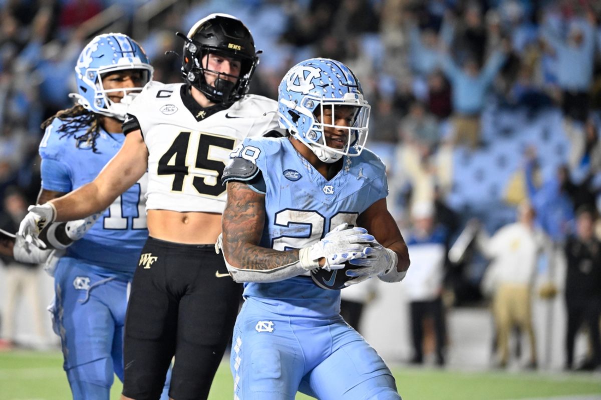 Nov 16, 2024; Chapel Hill, North Carolina, USA; North Carolina Tar Heels running back Omarion Hampton (28) scores a touchdown as Wake Forest Demon Deacons defensive back Nick Andersen (45) defends in the fourth quarter at Kenan Memorial Stadium. Mandatory Credit: Bob Donnan-Imagn Images