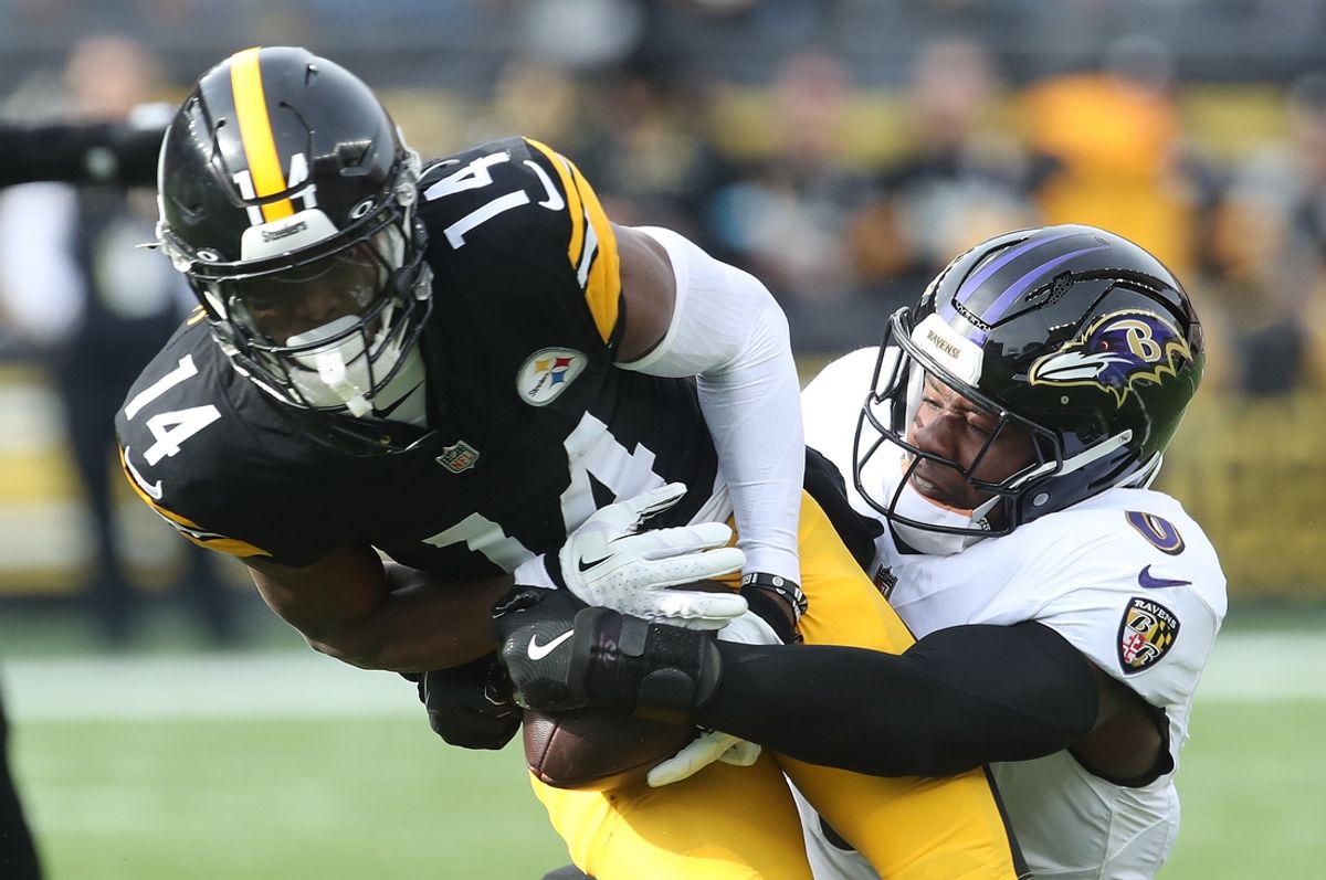 Nov 17, 2024; Pittsburgh, Pennsylvania, USA;  Pittsburgh Steelers wide receiver George Pickens (14) runs after a  catch as Baltimore Ravens linebacker Roquan Smith (0) defends during the first quarter at Acrisure Stadium. Mandatory Credit: Charles LeClaire-Imagn Images