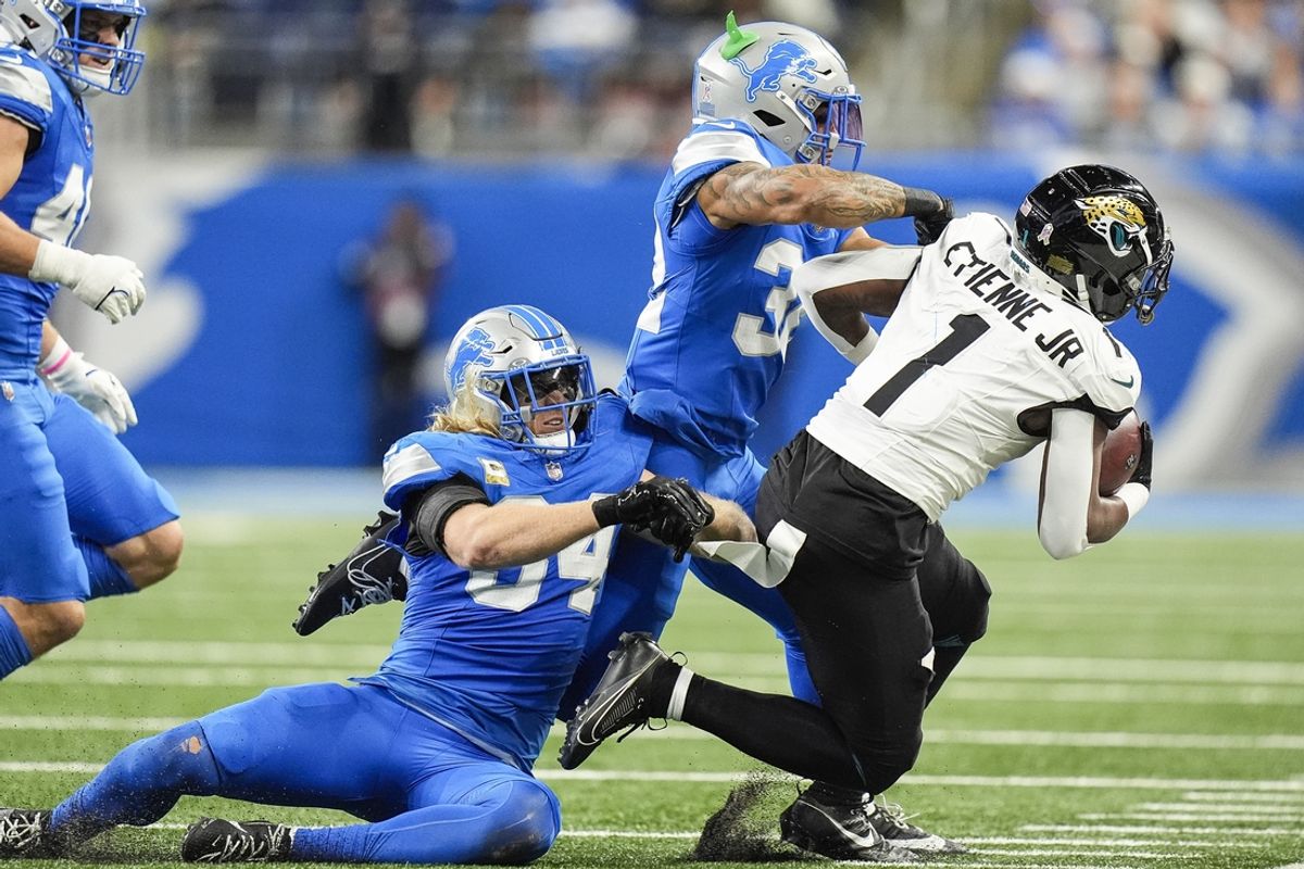Nov 17, 2024; Detroit, MI, USA; Detroit Lions linebacker Alex Anzalone (34) and safety Brian Branch (32) tackle Jacksonville Jaguars running back Travis Etienne Jr. (1) during the first half at Ford Field in Detroit on Sunday, Nov. 17, 2024. Mandatory Credit: Junfu Han/USA TODAY Network via Imagn Images