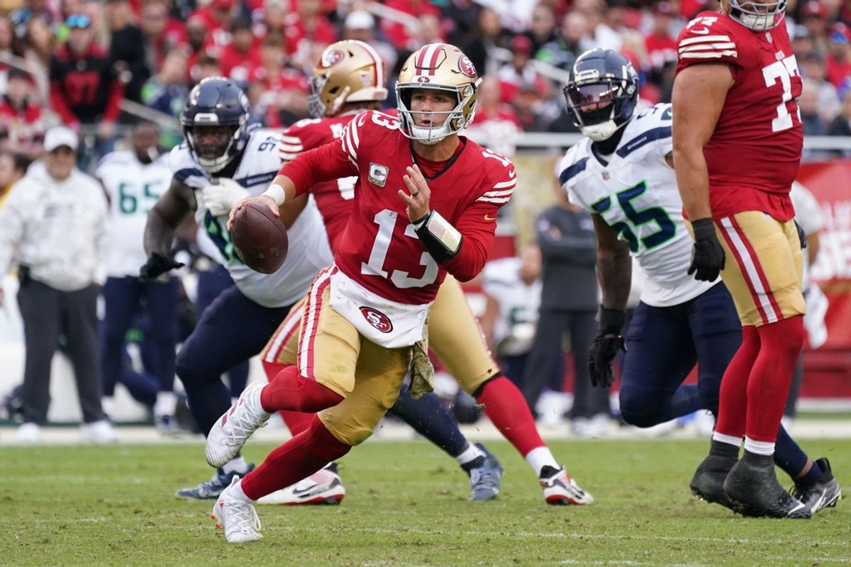 Nov 17, 2024; Santa Clara, California, USA; San Francisco 49ers quarterback Brock Purdy (13) scrambles away from Seattle Seahawks offensive tackle Michael Jerrell (65) in the third quarter at Levi's Stadium. Mandatory Credit: David Gonzales-Imagn Images