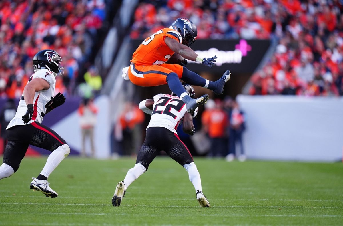 Nov 17, 2024; Denver, Colorado, USA; Denver Broncos running back Audric Estime (23) hurdles over Atlanta Falcons cornerback Clark Phillips III (22) in the second half at Empower Field at Mile High. Mandatory Credit: Ron Chenoy-Imagn Images