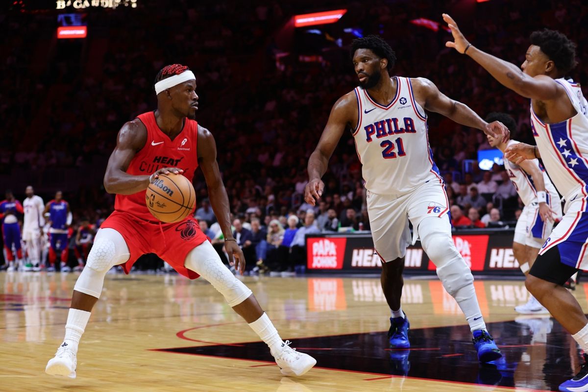 Nov 18, 2024; Miami, Florida, USA; Miami Heat forward Jimmy Butler (22) drives to the basket against Philadelphia 76ers center Joel Embiid (21) and guard Kyle Lowry (7) during the second quarter at Kaseya Center. Mandatory Credit: Sam Navarro-Imagn Images