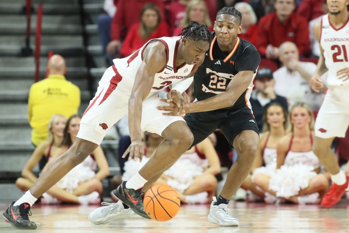 Nov 18, 2024; Fayetteville, Arkansas, USA; Pacific Tigers guard Elijah Fisher (22) defends in the first half against  Arkansas Razorbacks forward Adou Thiero (3) during the first half at Bud Walton Arena. Mandatory Credit: Nelson Chenault-Imagn Images
