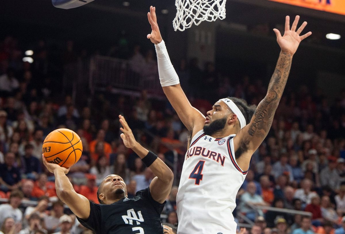 North Alabama Lions guard Daniel Ortiz (2) goes up for a layup defended by Auburn Tigers forward Johni Broome (4) as Auburn Tigers take on North Alabama Lions at Neville Arena in Auburn, Ala., on Monday, Nov. 18, 2024.