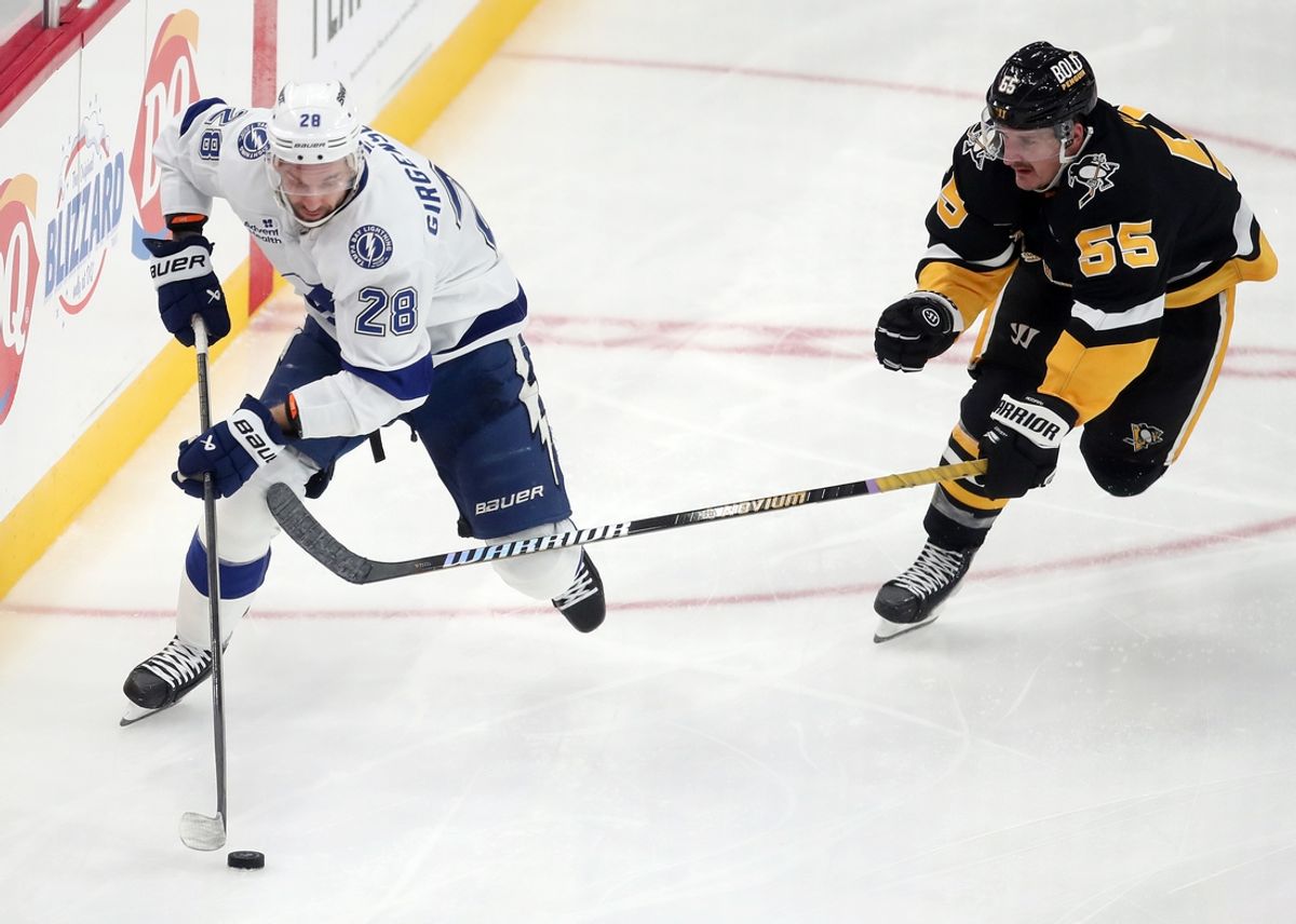 Nov 19, 2024; Pittsburgh, Pennsylvania, USA; Tampa Bay Lightning center Zemgus Girgensons (28) moves the puck ahead of Pittsburgh Penguins center Noel Acciari (55) during the second period at PPG Paints Arena. Mandatory Credit: Charles LeClaire-Imagn Images