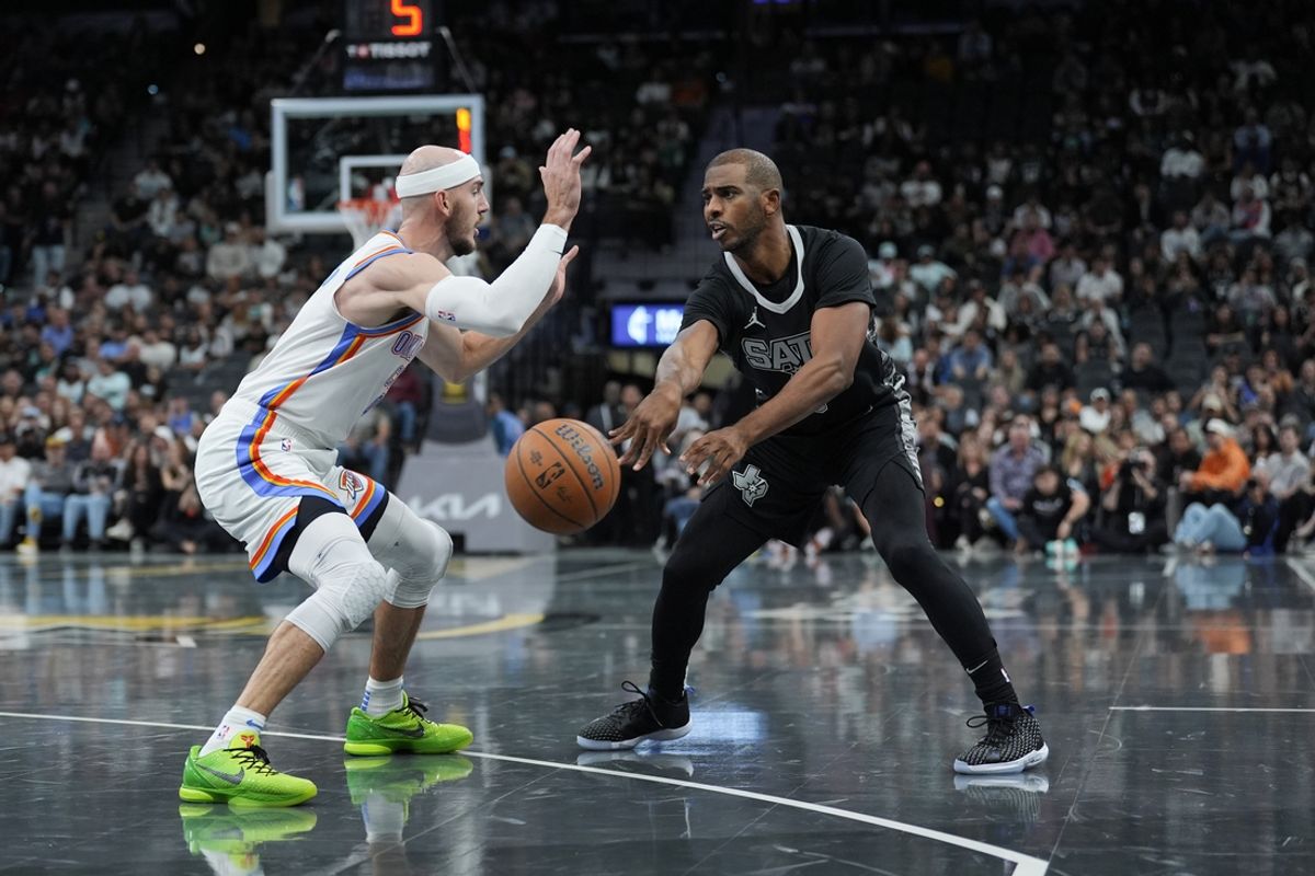 Nov 19, 2024; San Antonio, Texas, USA;  San Antonio Spurs guard Chris Paul (3) passes the ball in front of Oklahoma City Thunder guard Alex Caruso (9) in the first half at Frost Bank Center. Mandatory Credit: Daniel Dunn-Imagn Images