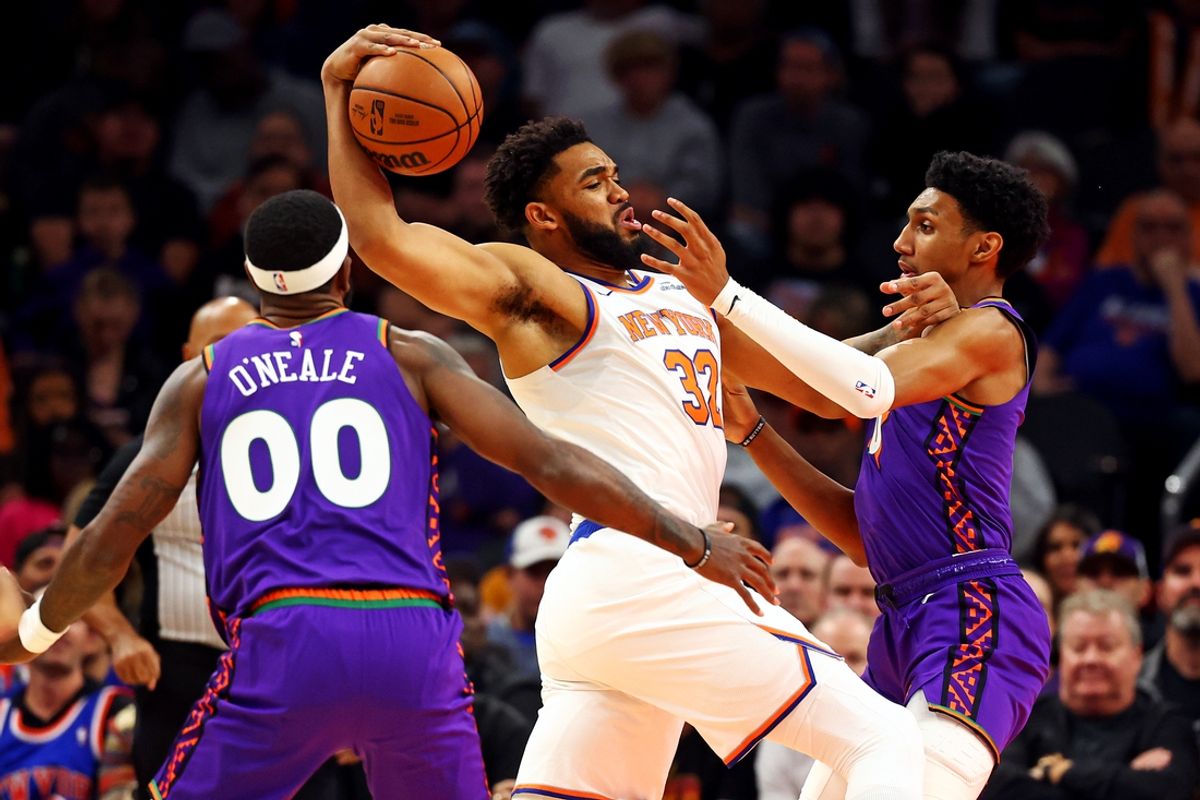 Nov 20, 2024; Phoenix, Arizona, USA; New York Knicks center Karl-Anthony Towns (32) drives to the basket against Phoenix Suns forward Royce O'Neale (00) and forward Ryan Dunn (0) during the first quarter at Footprint Center. Mandatory Credit: Mark J. Rebilas-Imagn Images