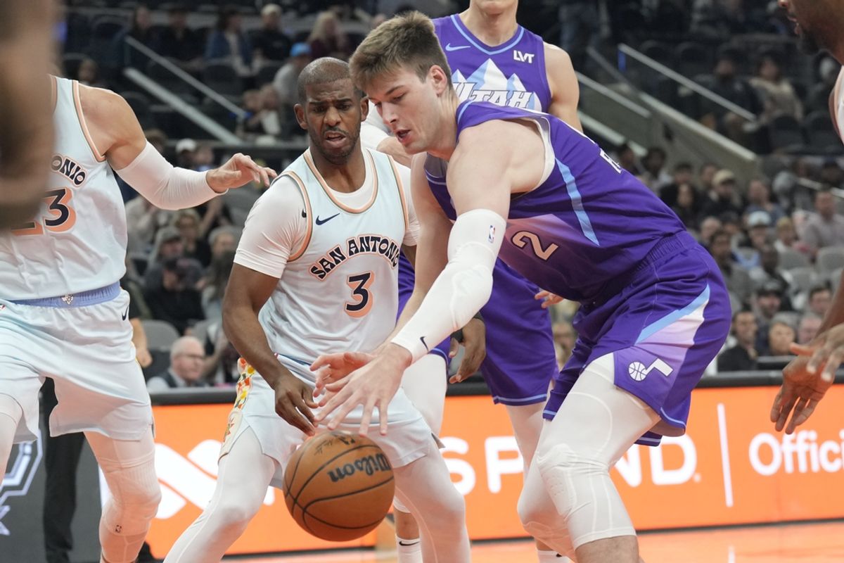 Nov 21, 2024; San Antonio, Texas, USA; Utah Jazz forward Kyle Filipowski (22) reaches for the ball while defended by San Antonio Spurs guard Chris Paul (3) during the first half at Frost Bank Center. Mandatory Credit: Scott Wachter-Imagn Images