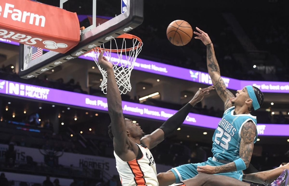 Nov 21, 2024; Charlotte, North Carolina, USA;  Charlotte Hornets guard Tre Mann (23) is fouled by Detroit Pistons center Jalen Duren (0) during the second half at the Spectrum Center. Mandatory Credit: Sam Sharpe-Imagn Images