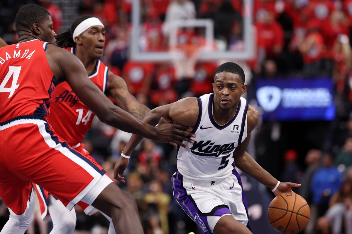 Nov 22, 2024; Inglewood, California, USA;  Sacramento Kings guard De'Aaron Fox (5) dribbles the ball against Los Angeles Clippers guard Terance Mann (14) and center Mo Bamba (4) during the fourth quarter at Intuit Dome. Mandatory Credit: Kiyoshi Mio-Imagn Images