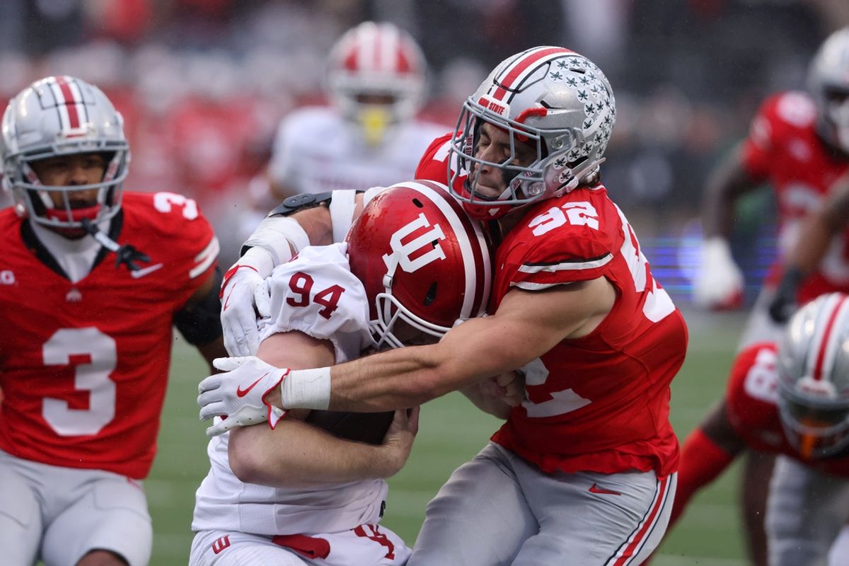 Nov 23, 2024; Columbus, Ohio, USA; Indiana Hoosiers punter James Evans (94) is tackled after recovering his fumble by Ohio State Buckeyes defensive end Caden Curry (92) and cornerback Lorenzo Styles Jr. (3) during the second quarter at Ohio Stadium. Mandatory Credit: Joseph Maiorana-Imagn Images