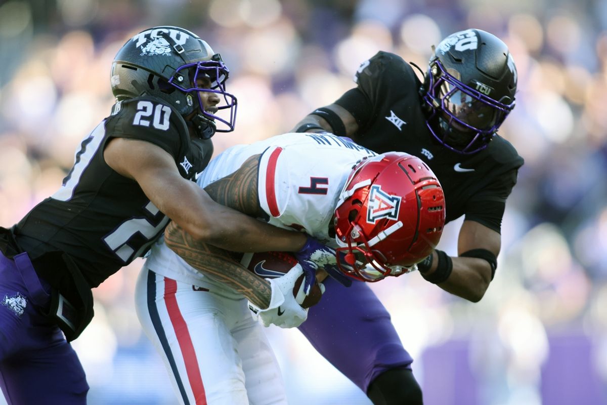 Nov 23, 2024; Fort Worth, Texas, USA; Arizona Wildcats wide receiver Tetairoa McMillan (4) catches a pass against TCU Horned Frogs cornerback Jevon McIver Jr. (20) and safety Jamel Johnson (2) in the second quarter at Amon G. Carter Stadium. Mandatory Credit: Tim Heitman-Imagn Images