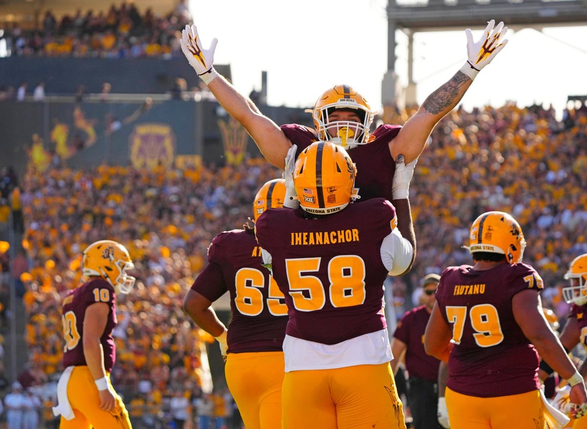 Arizona State offensive lineman Max Iheanachor (58) lifts Arizona State running back Cam Skattebo (4) after a touchdown against BYU during the first half at Mountain America Stadium in Tempe on Nov. 23, 2024.