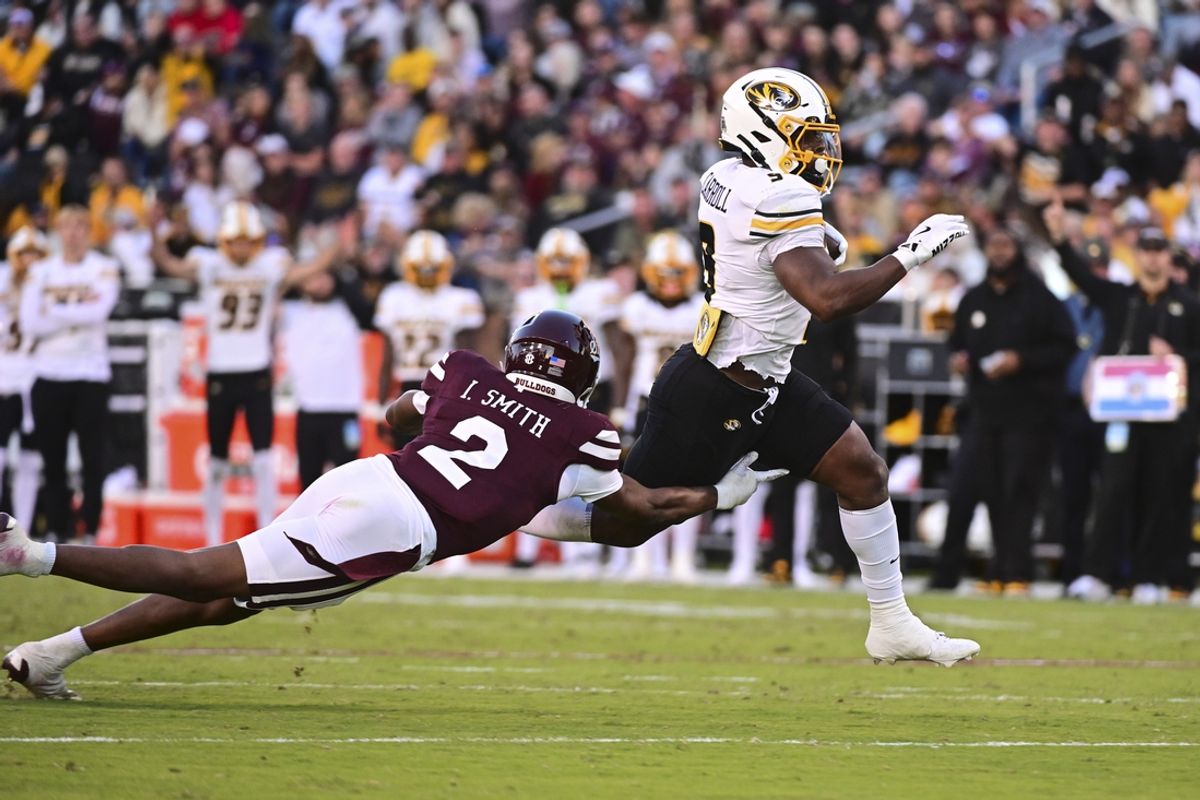 Nov 23, 2024; Starkville, Mississippi, USA;  Missouri Tigers running back Marcus Carroll (9) runs against Mississippi State Bulldogs safety Isaac Smith (2) during the second quarter at Davis Wade Stadium at Scott Field. Mandatory Credit: Matt Bush-Imagn Images