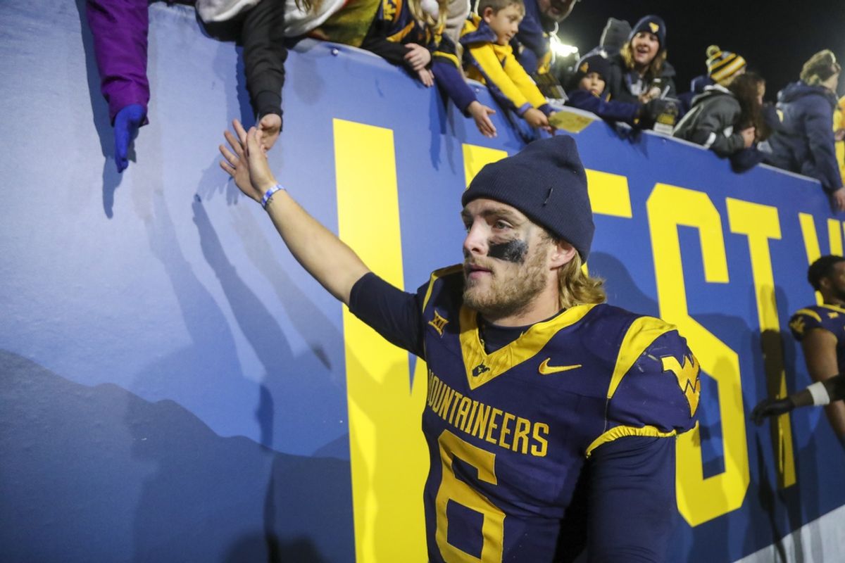 Nov 23, 2024; Morgantown, West Virginia, USA; West Virginia Mountaineers quarterback Garrett Greene (6) celebrates with fans after defeating the UCF Knights at Mountaineer Field at Milan Puskar Stadium. Mandatory Credit: Ben Queen-Imagn Images
