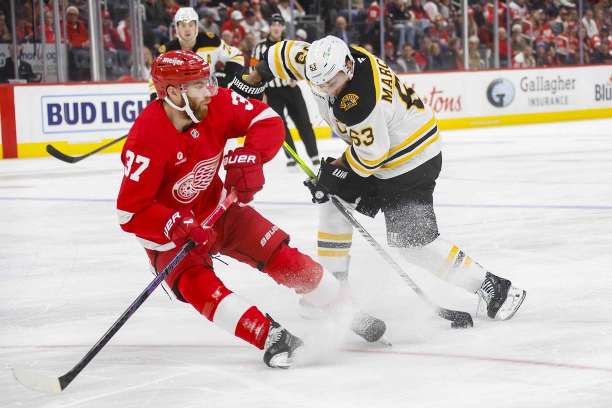 Nov 23, 2024; Detroit, Michigan, USA; Boston Bruins left wing Brad Marchand (63) handles the puck against Detroit Red Wings left wing J.T. Compher (37) during the first period at Little Caesars Arena. Mandatory Credit: Brian Bradshaw Sevald-Imagn Images